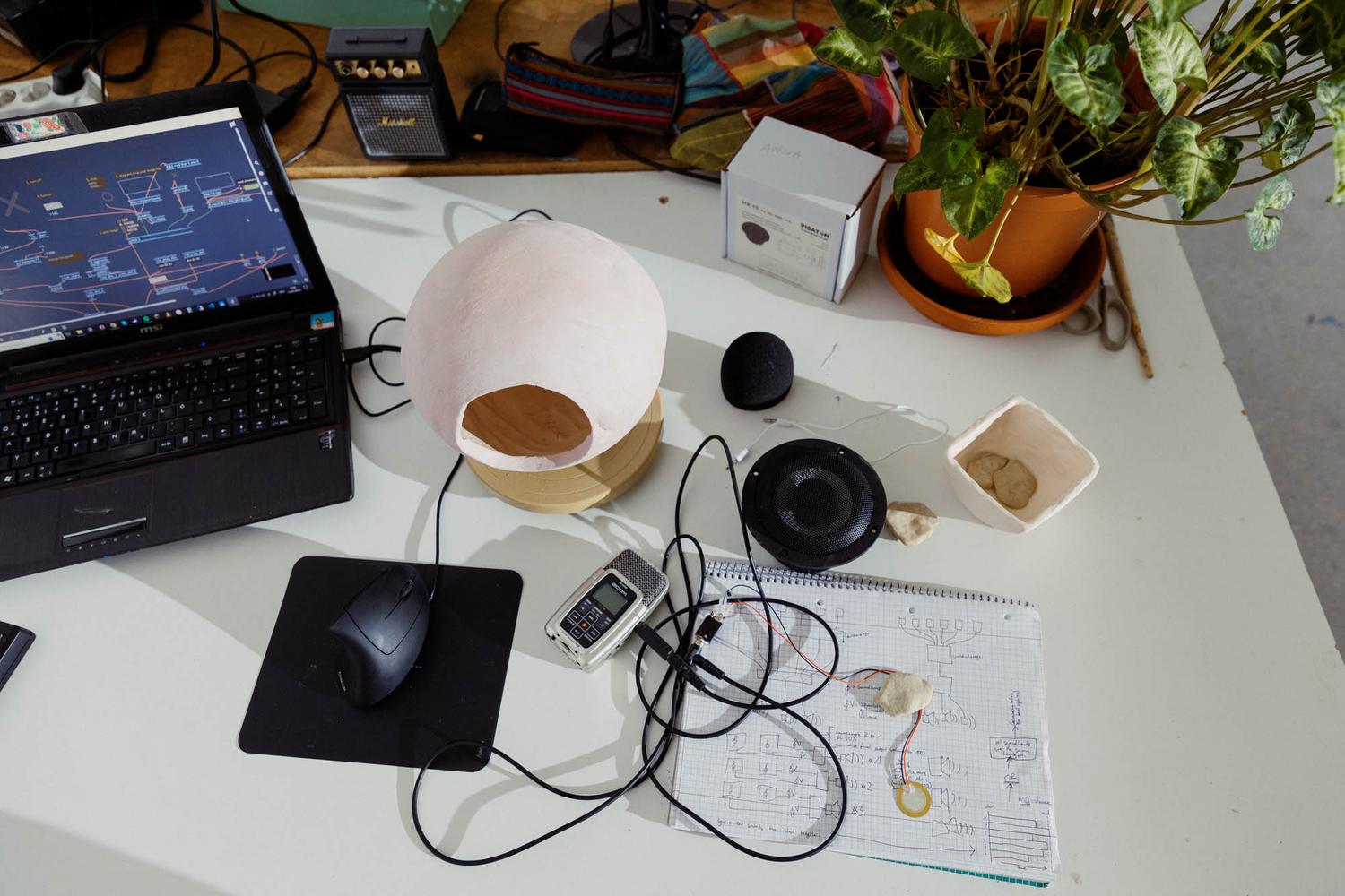 Photo by Scheiber Pötter, depicting my working desp with Laptop and MaxMSP, the unglazed ceramic speakers and the tech to go into it.